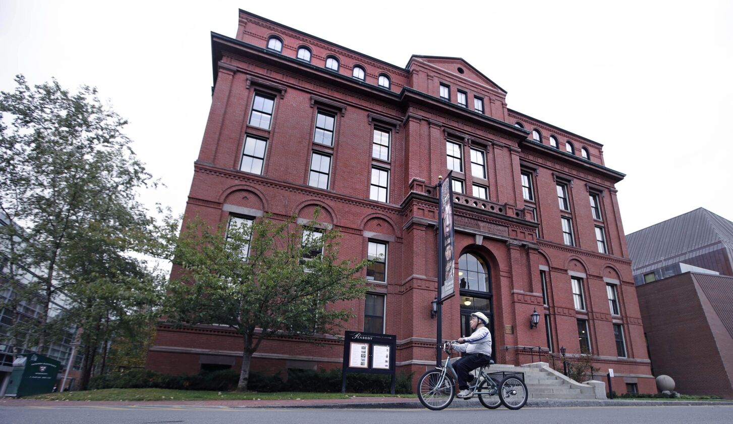 A cyclist rolls past the Peabody Museum of Archaeology & Ethnology at Harvard University in Cambridge, Mass. | (AP Photo/Charles Krupa)